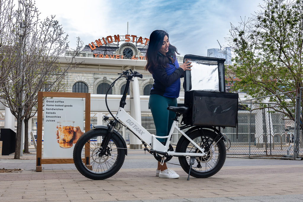 Woman using the Rear Storage Rack on the GOTRAX F2 Foldable Electric Bike for Groceries