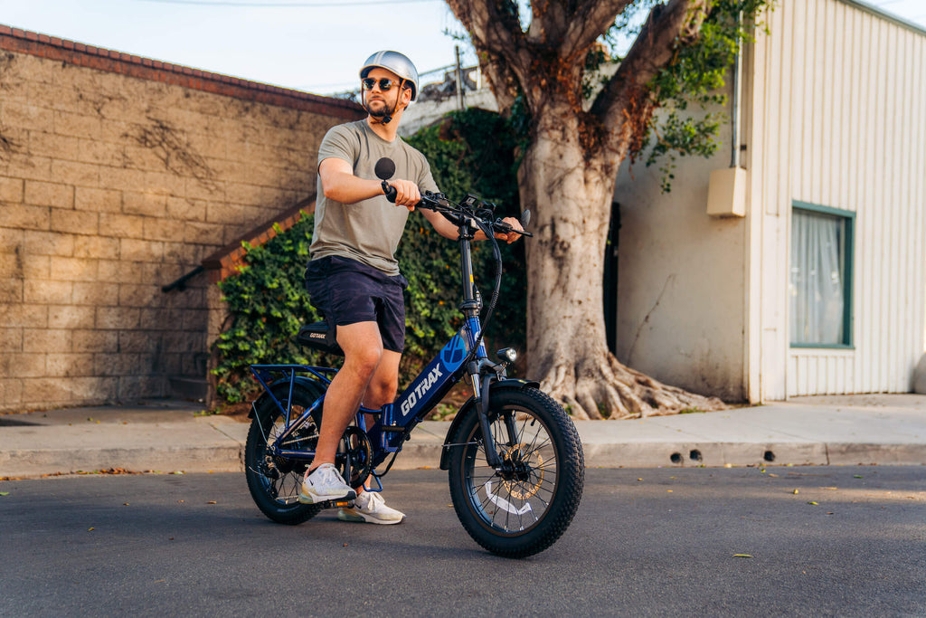A man riding the GOTRAX F2 V2 folding electric bike for adults with 5 free accessories.