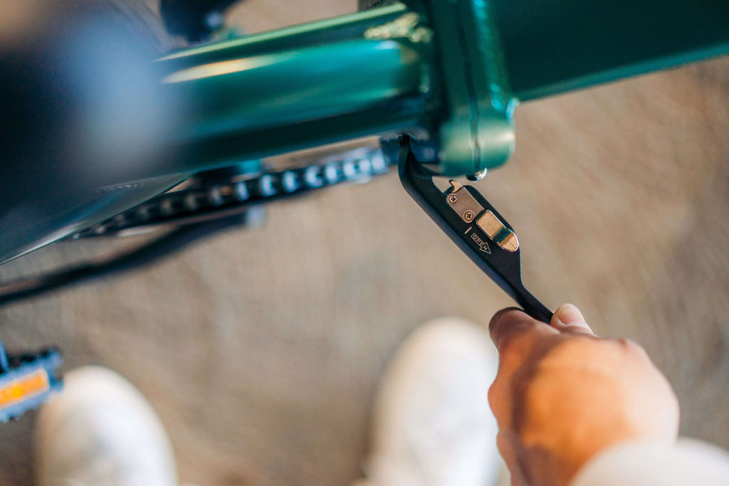 A woman folding the frame of the GOTRAX F1 Folding Electric Bike.