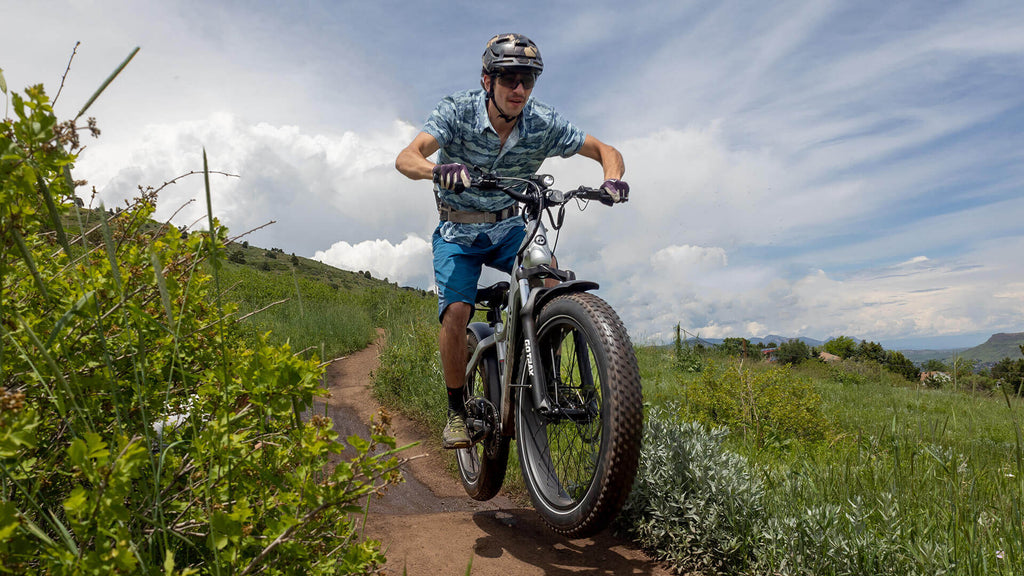 Man riding the GOTRAX Tundra All-Terrain Electric Bike on a Off Road Trail